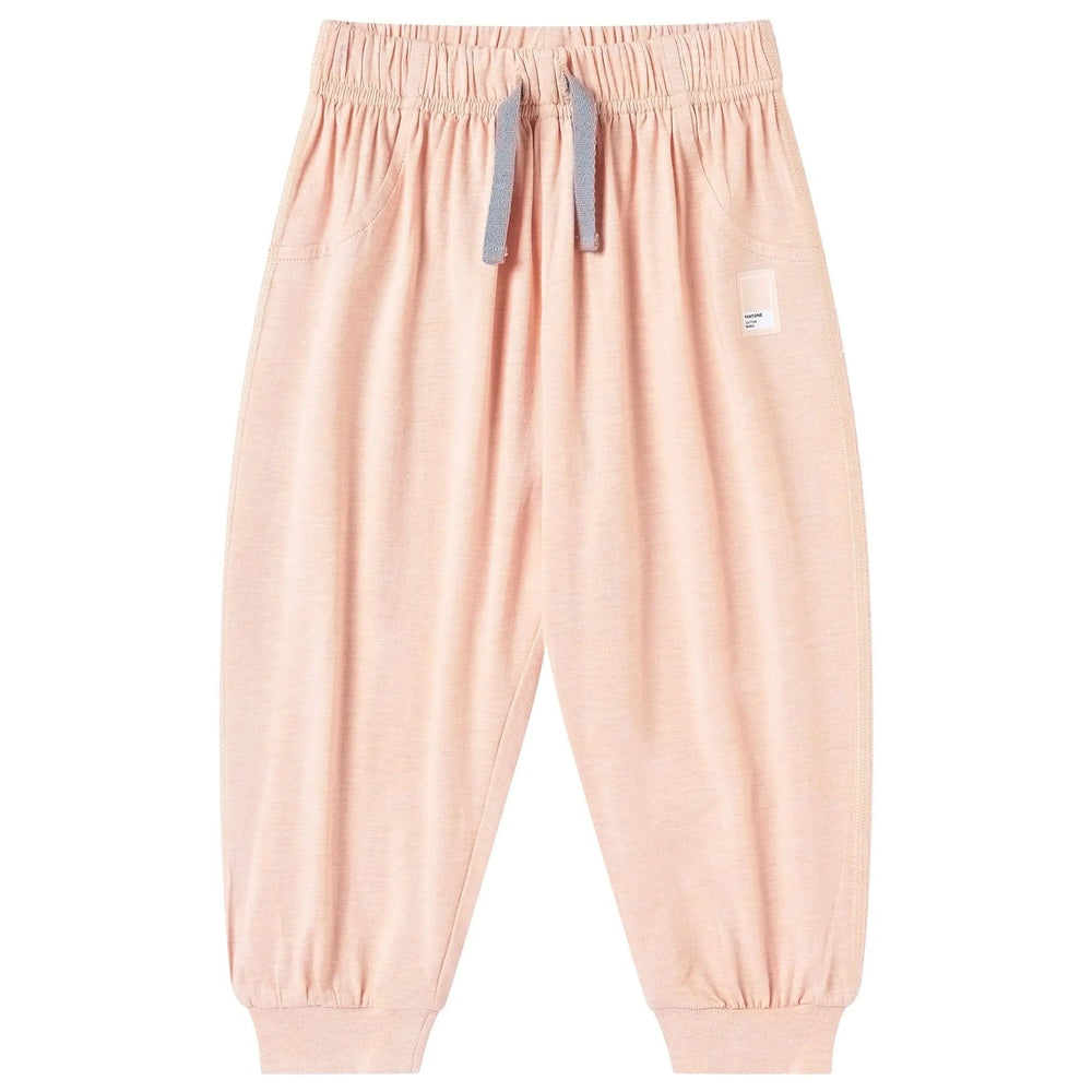 Nest Designs Bamboo Jersey Harem Pants Pantone Bellini pink with a blue drawstring tied at the elastic waist and cuffed ankles.
