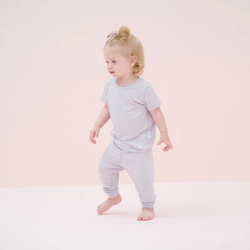 Nest Designs Bamboo Jersey Short Sleeve Pajama Set Lavender Blue worn by a toddler in matching top and pants, barefoot.