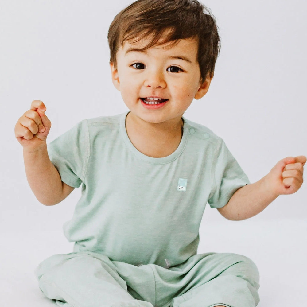 Nest Designs bamboo jersey short sleeve t-shirt and pants in mint green, worn by a happy toddler.