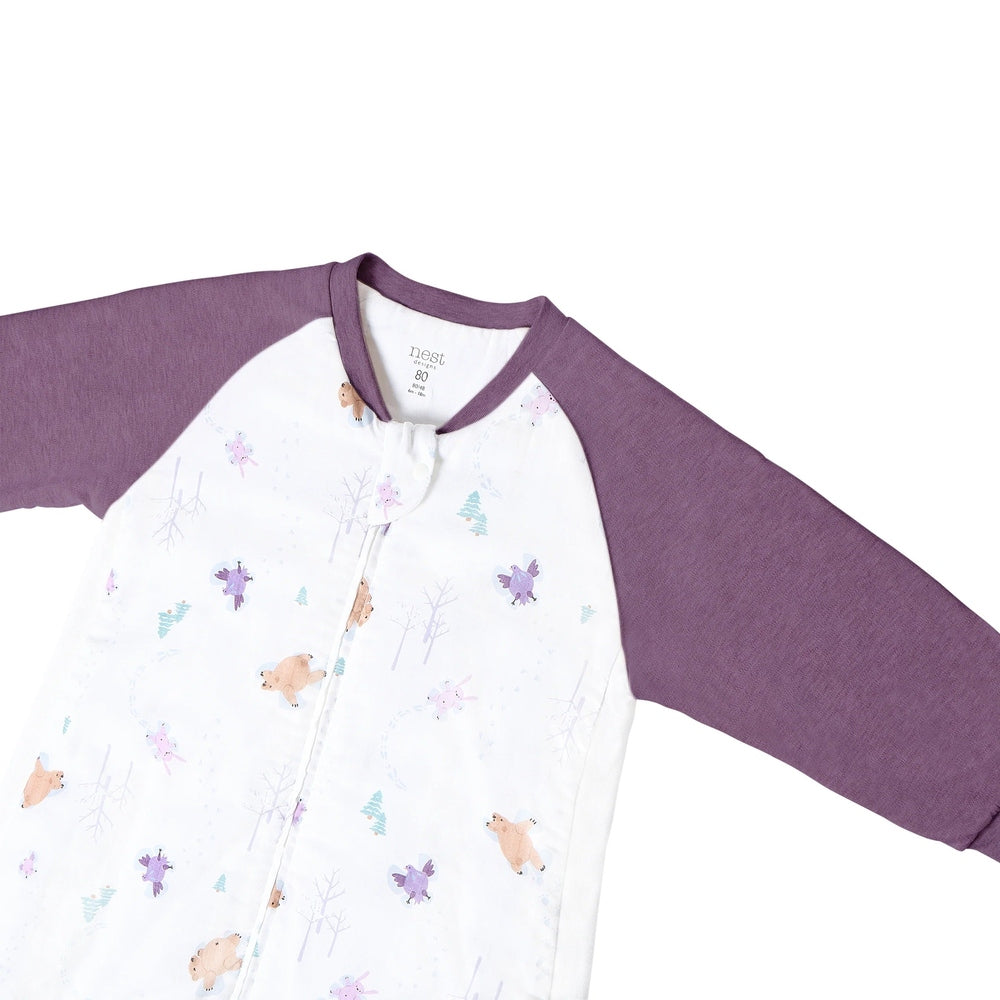 Nest Designs Bamboo Long Sleeve Footed Sleep Bag 1.0 Tog Snow Angels in purple sleeves, white body with woodland print.