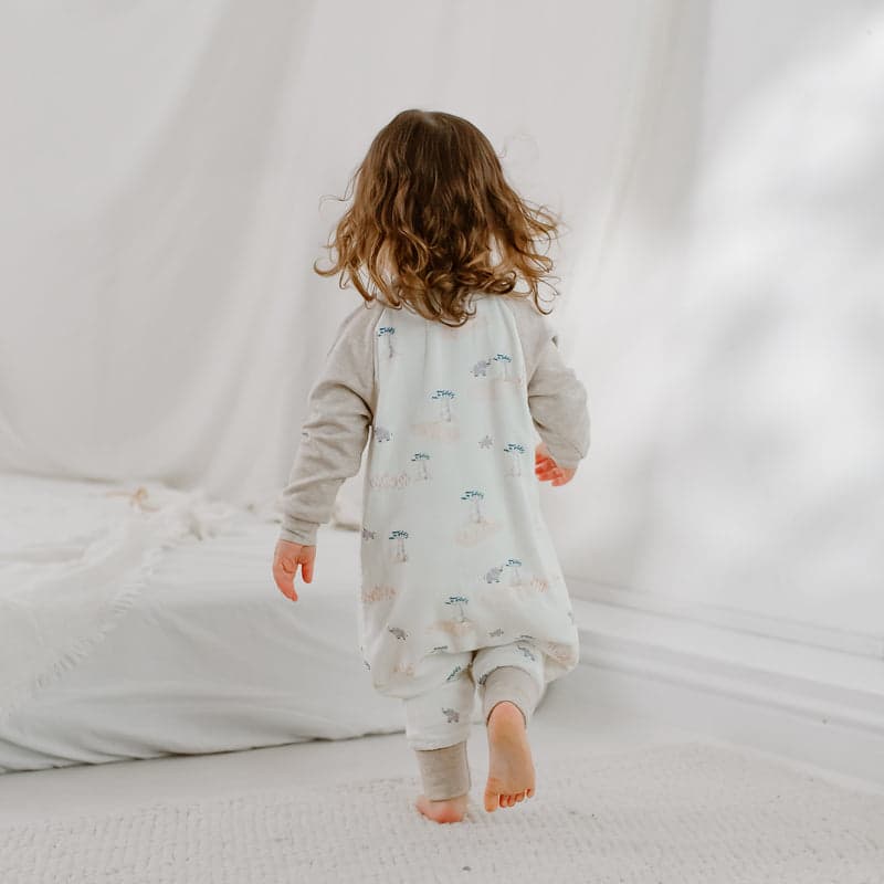 Nest Designs Bamboo long sleeve footed sleep bag 1.0 Tog with Baobabs pattern; toddler walks away showing feet.