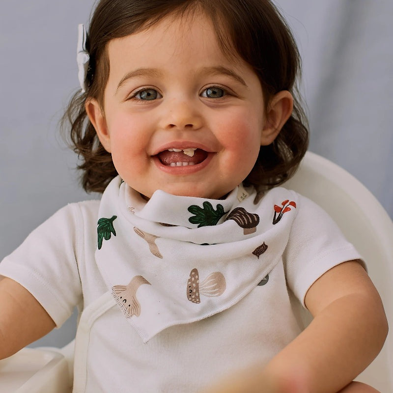 Nest Designs bamboo muslin baby bandana bib Forest Forage on a smiling toddler