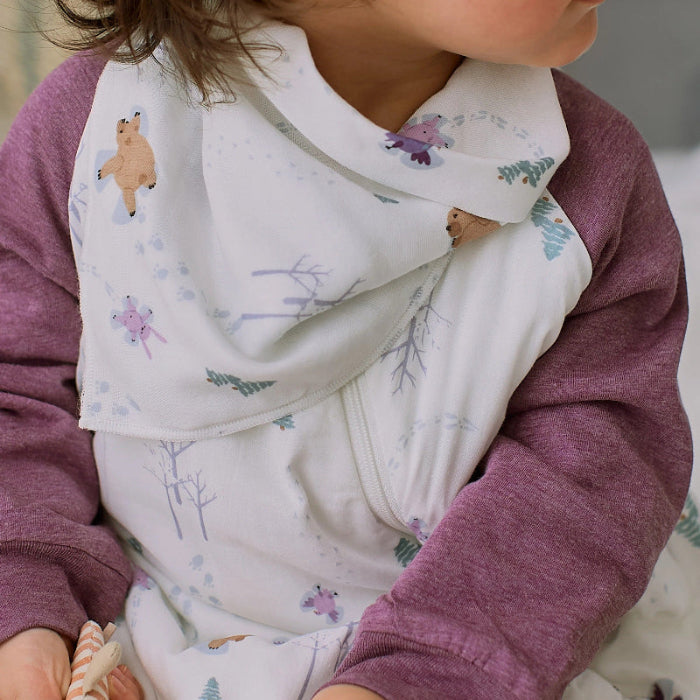 Nest Designs Bamboo Muslin Baby Bandana Bib Snow Angels on a toddler, white with pale prints, worn over maroon sleeves