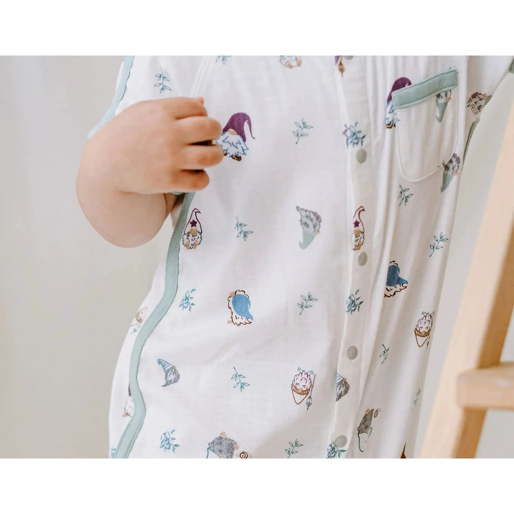 Nest Designs Bamboo Short Sleeve Romper Oh Gnome in white with light blue piping, gnome prints, worn by a baby.