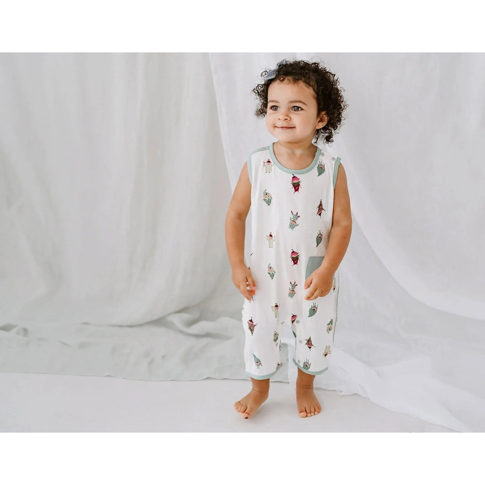 Nest Designs Bamboo Sleeveless Romper Pixie Dust; white with mint trim and cactus print, toddler stands barefoot.