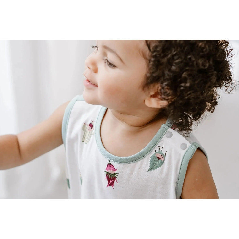 Nest Designs Bamboo Sleeveless Romper Pixie Dust in white with mint trim; baby reaches toward a sheer curtain.