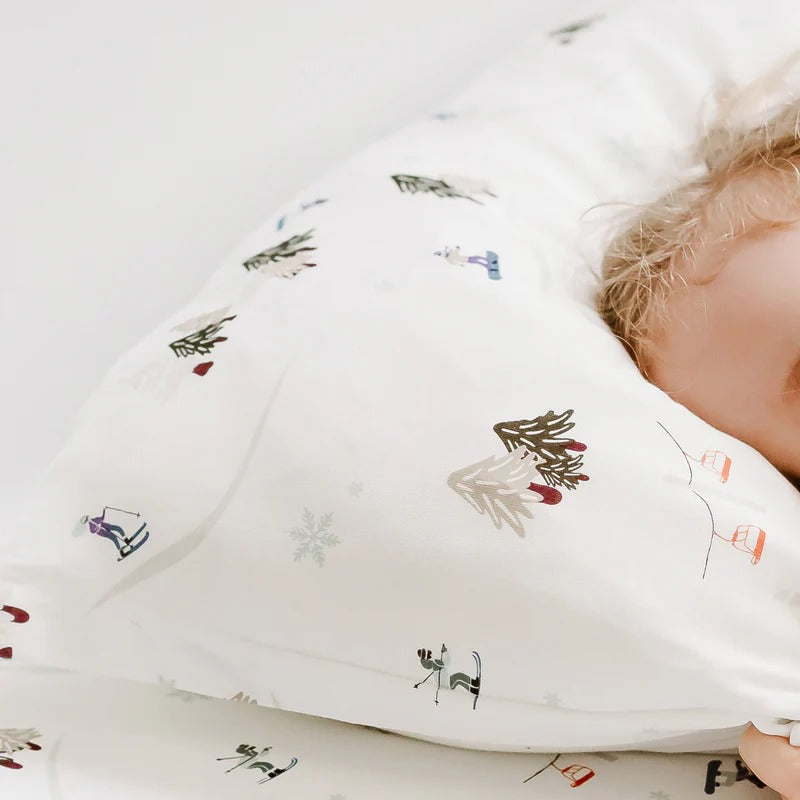 Nest Designs Bamboo Toddler Pillowcase Chills N' Thrills white with winter prints gently draped over a sleeping toddler