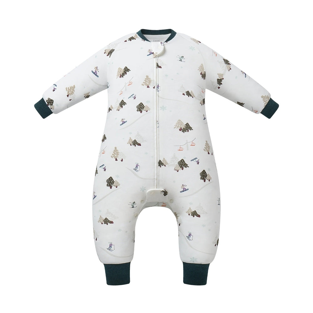 Nest Designs Cotton Long Sleeve Footed Sleep Bag 1.0 Tog, white with pine trees and skiers; teal cuffs secure warmth.