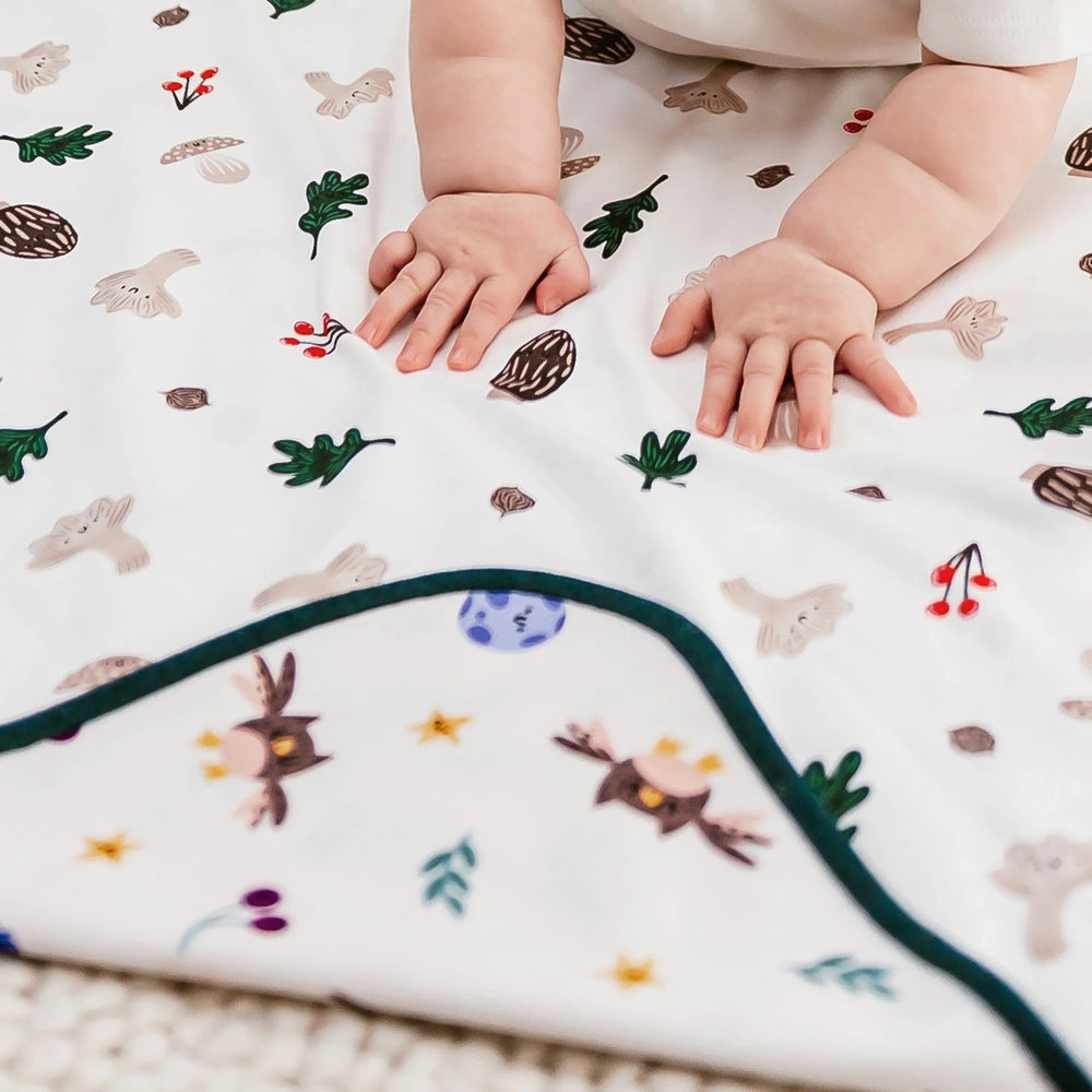 Nest Designs cotton waterproof baby change pad, small white with woodland print, hands on mat