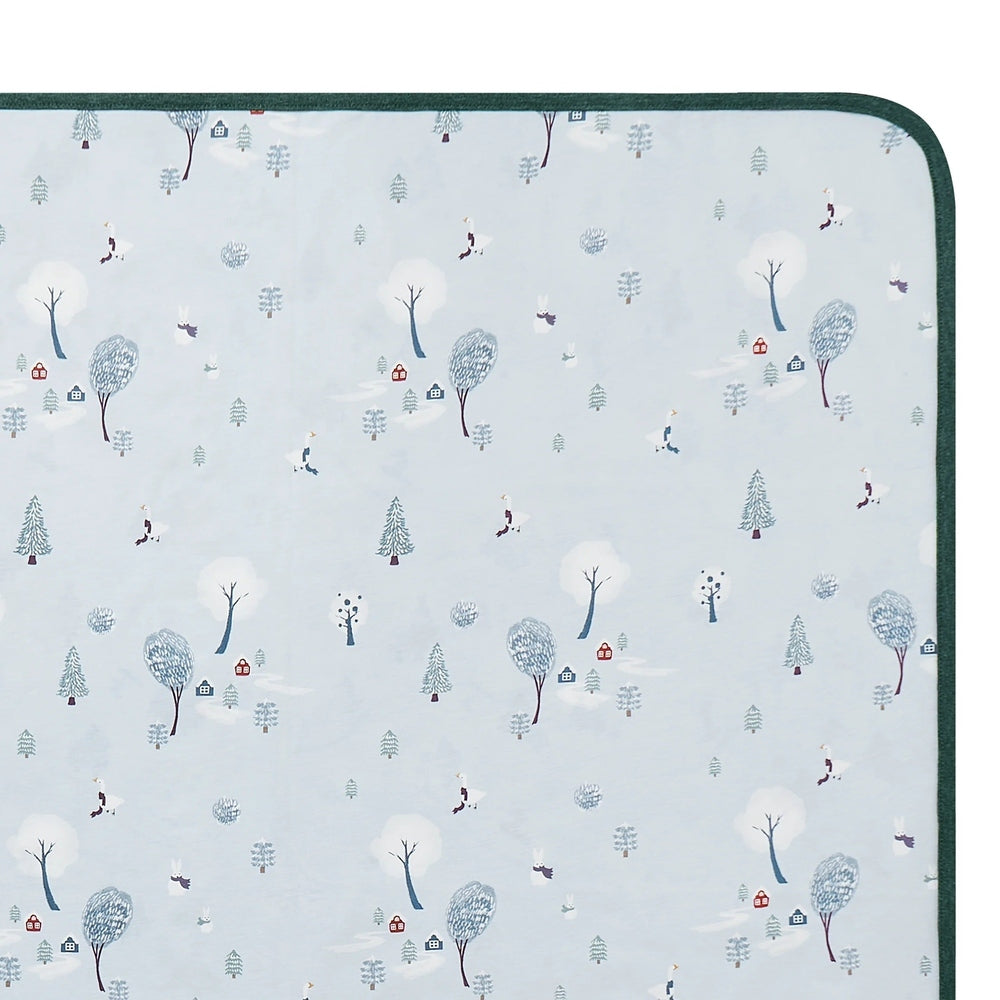 Nest Designs Cotton Waterproof Change Pad Large Winter Fun laid flat with teal border and snowy trees motif.