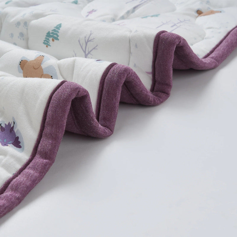Nest Designs Cozy Blanket Small Snow Angels, white with purple plush border, folded to show the soft edge.