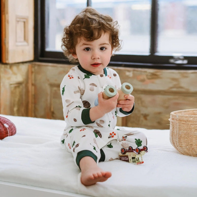 Nest Designs long-sleeve romper in forest forage print for babies, white with woodland motifs