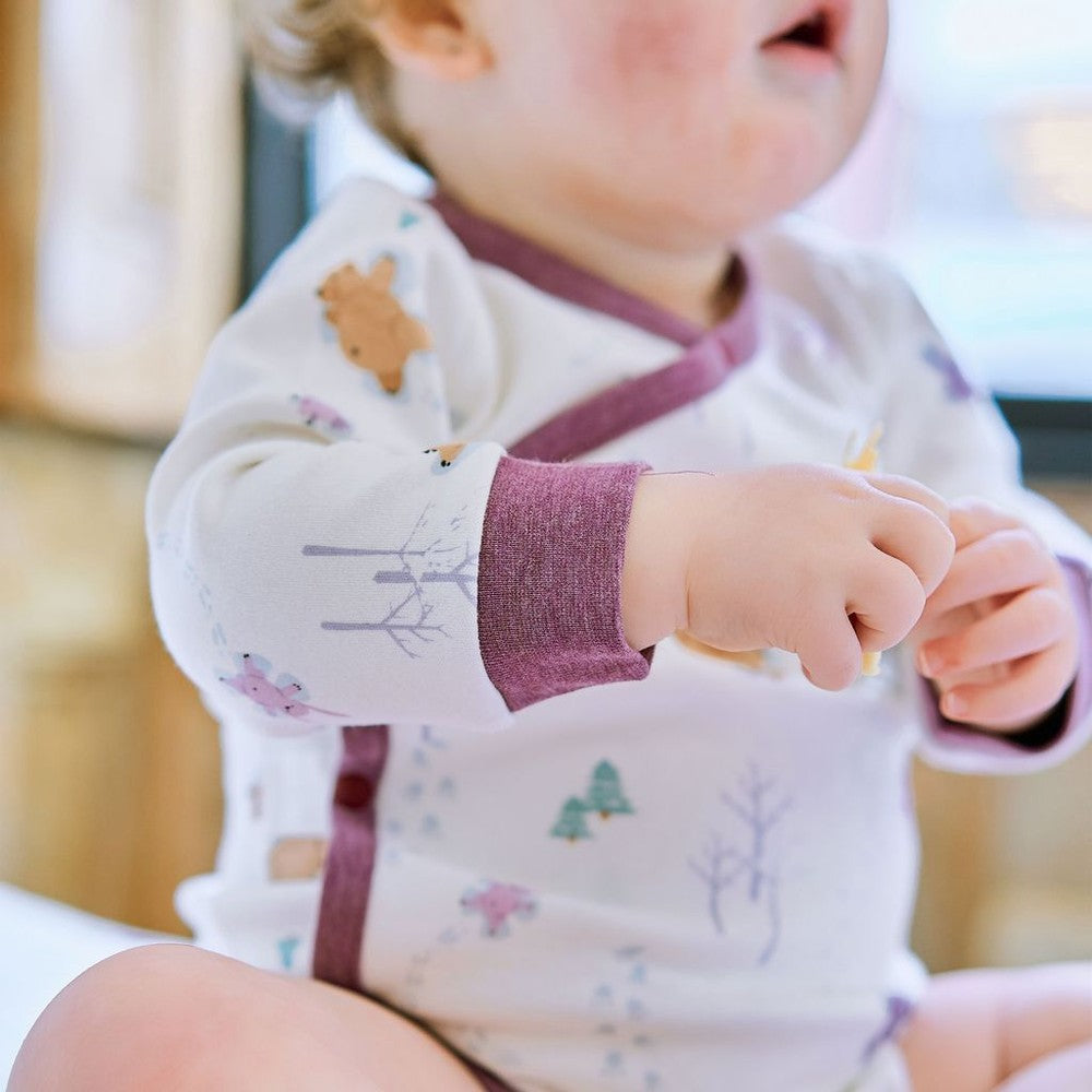 Nest Designs organic cotton long-sleeve kimono onesie in white with purple cuffs and woodland snow angels print