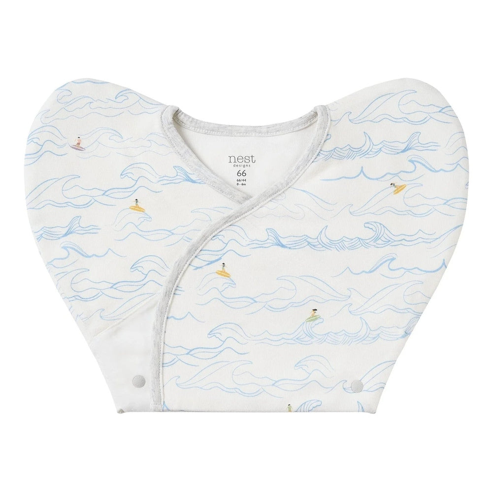 Nest Designs Organic Cotton Startle Stop Sleep Bag 0.5 Tog Surf's Cup, white with blue waves, wrap-fastened at front.