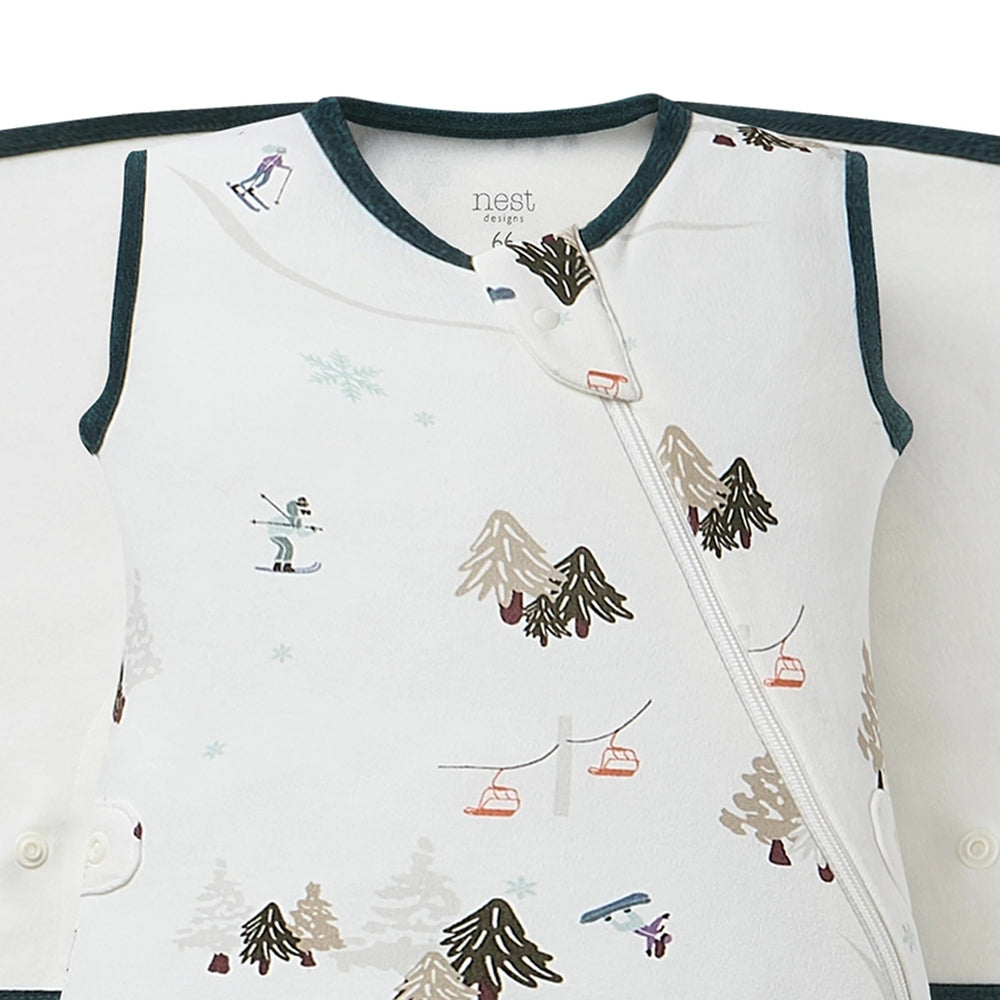 Nest Designs Organic Cotton Startle Stop Sleep Bag 0.5 Tog Chills N' Thrills: white with teal trim, winter scene prints, diagonal zipper.