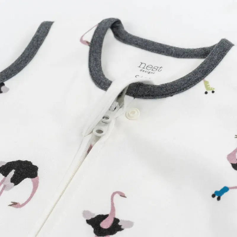 Nest Designs Organic Cotton Swaddle Sleep Bag 1.0 Tog 0-6M in white with grey trim and flamingo print, shown zipped.