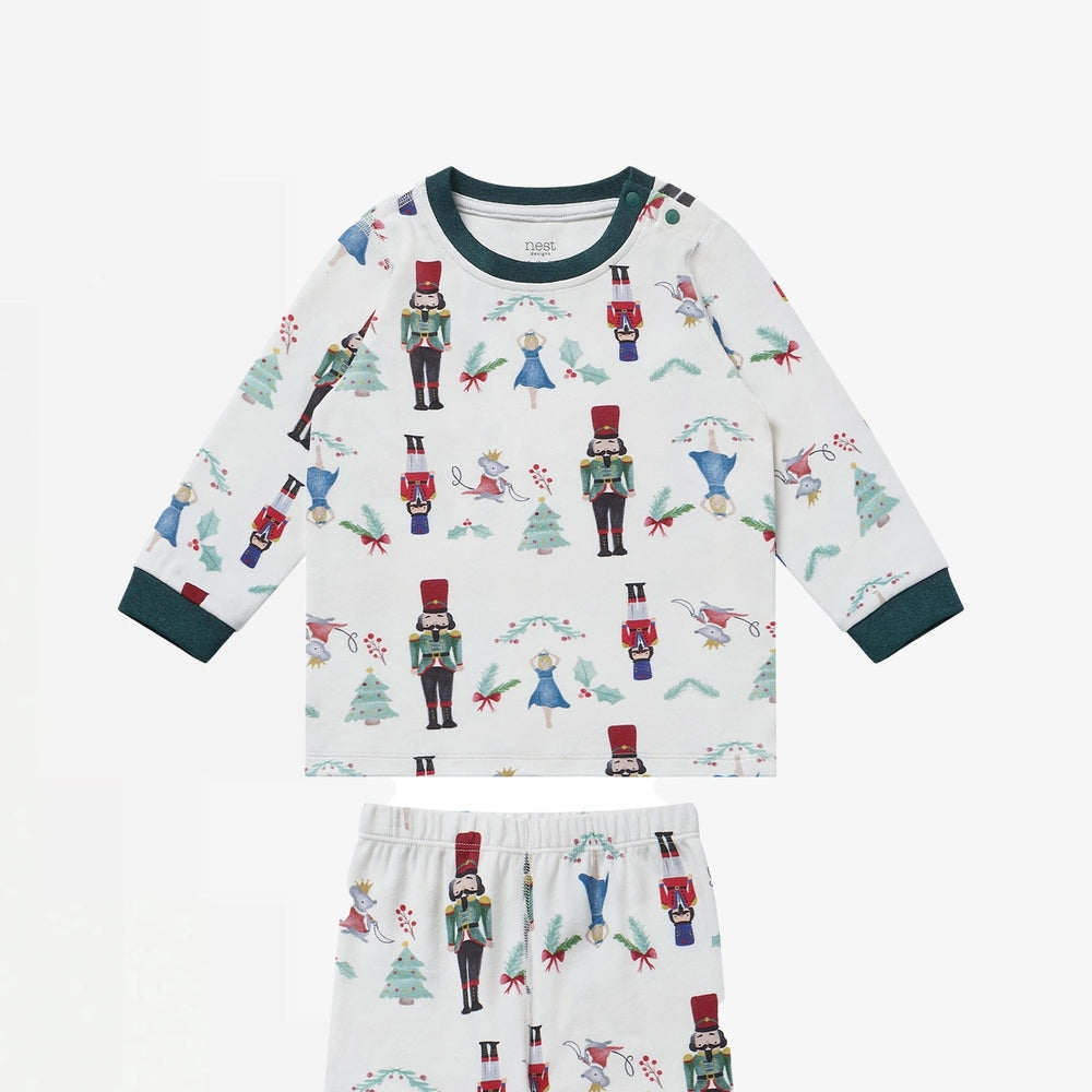 Nest Designs Organic Cotton Two-Piece Long Sleeve Pajama Set Nutcracker—white with green cuffs and nutcracker prints.