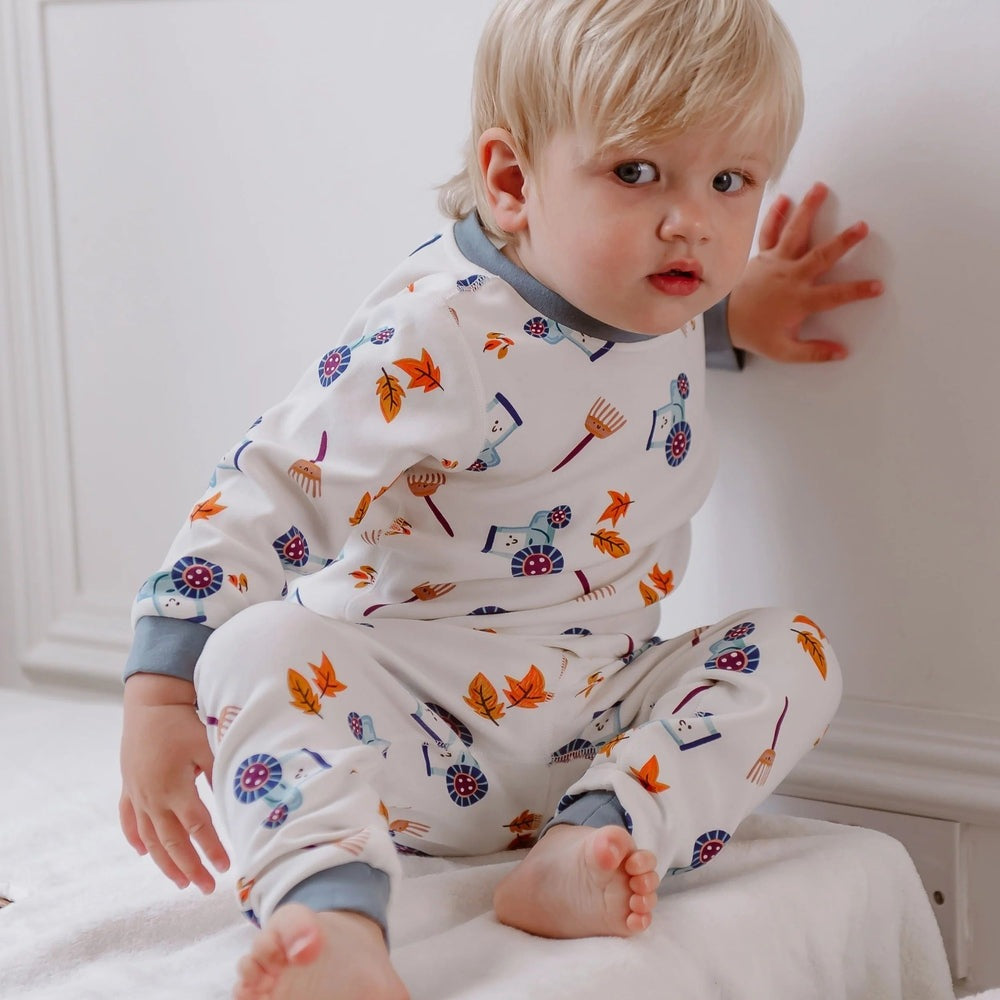 Nest Designs Organic Cotton Farm Pajama Set for toddlers; white with blue-gray cuffs and colorful farm-print motifs