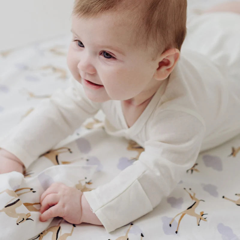 Nest Designs Organic Cotton Waterproof Change Pad Sahara Sky; baby on a patterned changing mat