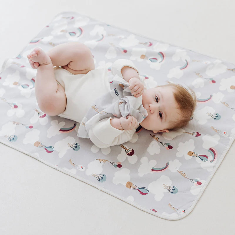 Nest Designs Organic Cotton Waterproof Change Pad Sahara Sky featuring a baby on a cloud-pattern mat