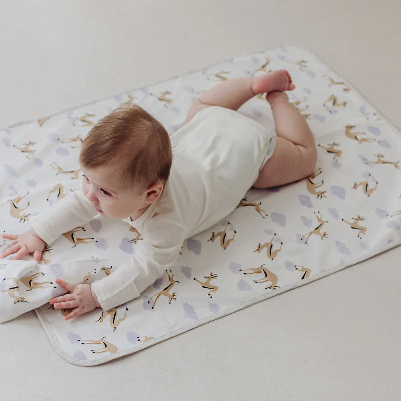 Nest Designs Organic Cotton Waterproof Change Pad Sahara Sky; baby on light patterned changing mat