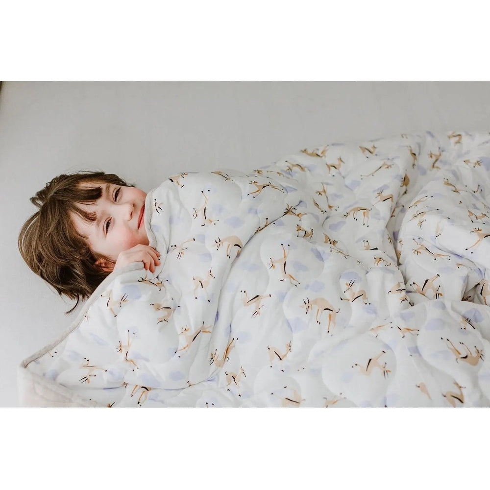 Nest Designs Quilted Bamboo Jersey Winter Blanket 3.2 Tog, large, pale blue/cream pattern keeping a child snug under the quilt.