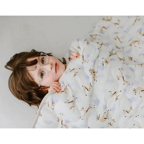 Nest Designs Quilted Bamboo Jersey Winter Blanket 3.2 Tog Large, white with pale blue cranes, wrapped around a sleeping person.