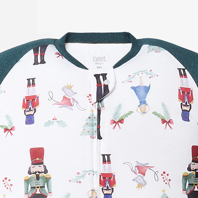 Nest Designs Raglan Bamboo Long Sleeve Footed Sleep Bag 2.5 Tog Nutcracker, white with Nutcracker print and dark teal cuffs.