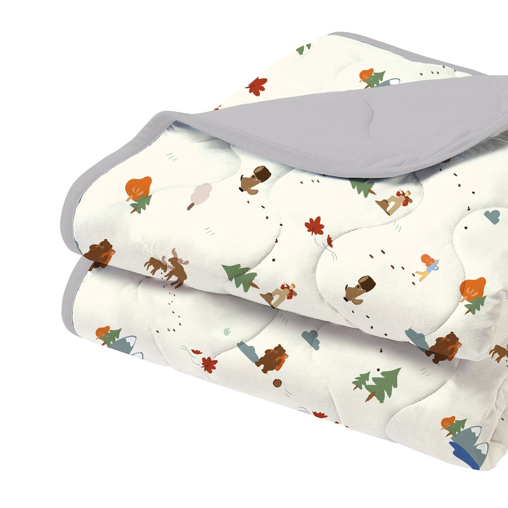 Nest Designs Small Cozy Blanket in soft white with woodland motifs and gray trim, neatly folded for display.
