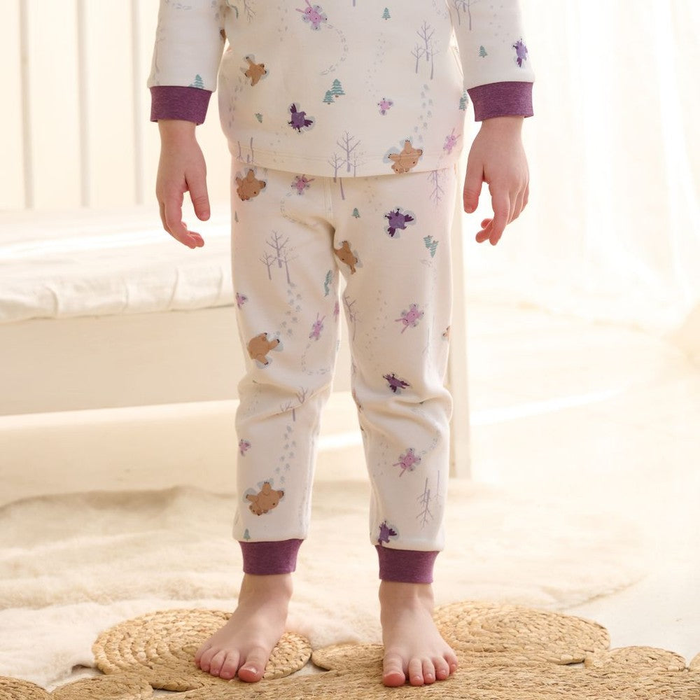 Nest Designs two-piece long-sleeve pajama set in cream with purple cuffs and snow angel print