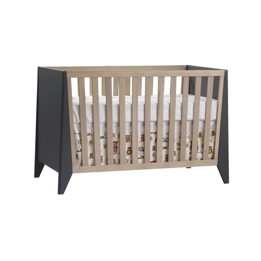 Nest Flexx Premium Classic Crib in natural birch with dark gray end panels, showing vertical slats and a ready mattress.