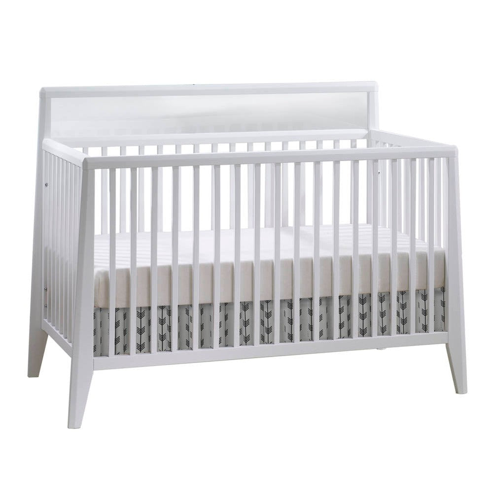 Nest Flexx Premium Convertible Crib in white with slatted sides and back panel, mattress sits inside.