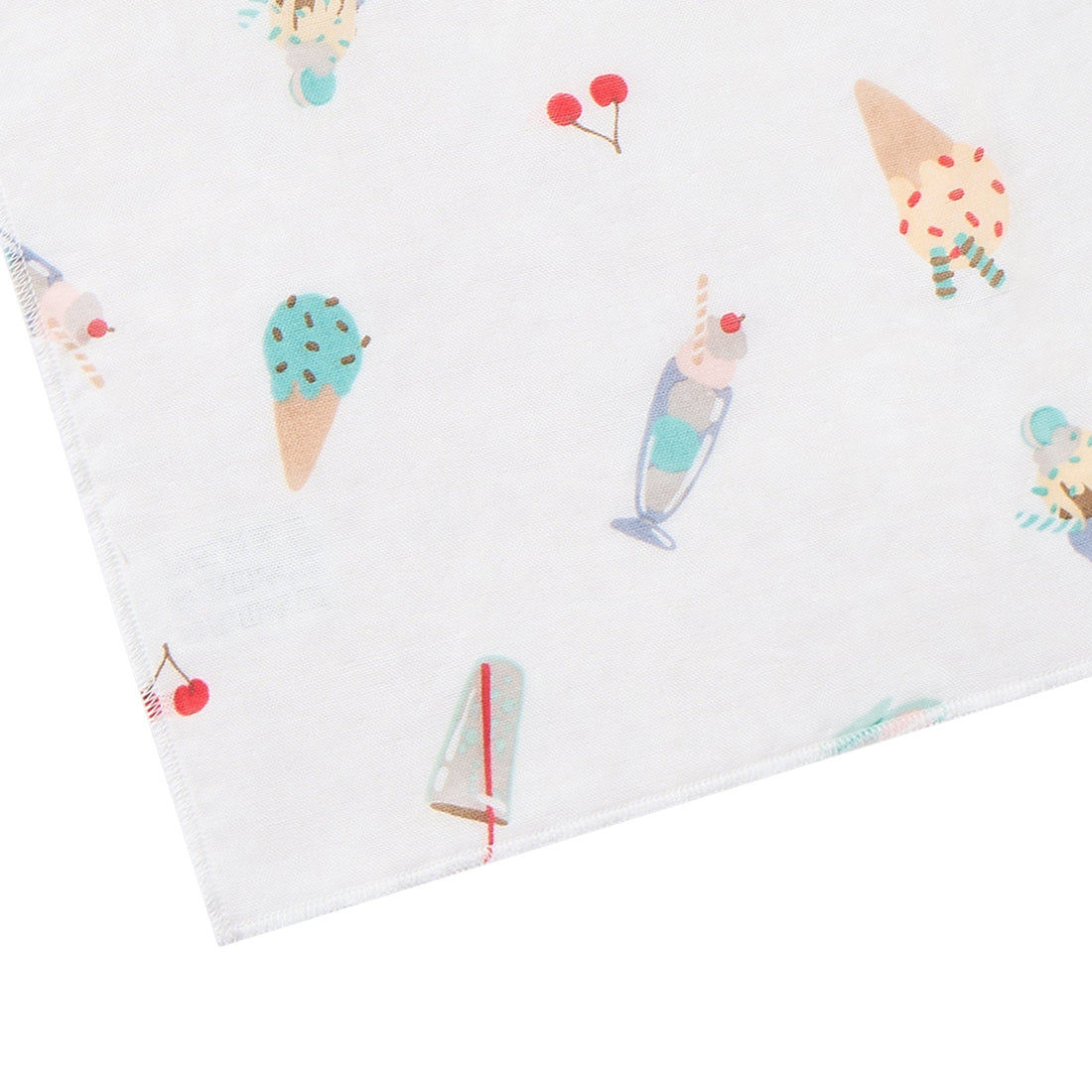 A close-up of a white fabric item, likely a blanket or towel, featuring a playful all-over print of ice cream cones, milkshakes, cherries, and sprinkles in pastel colors.
