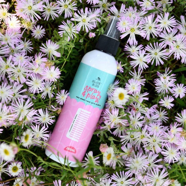 No Nasties Kids lavender and fresh lime hair spray, 200 ml bottle with pastel label among purple flowers