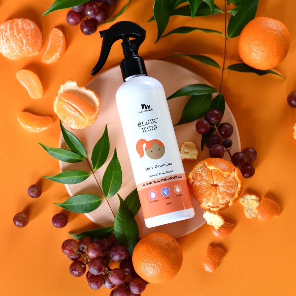 No Nasties Plant Based Hair Detangler 250 ml Mandarin & Grape spray bottle with orange backdrop and citrus fruits.