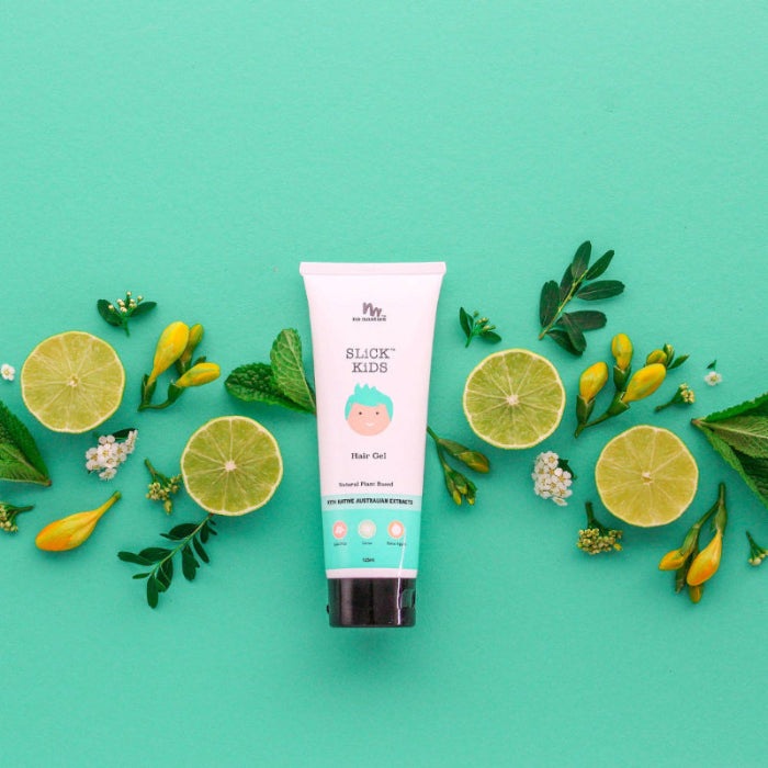 No Nasties Slick Kids Hair Gel tube standing upright on teal background amid lime slices and greenery.