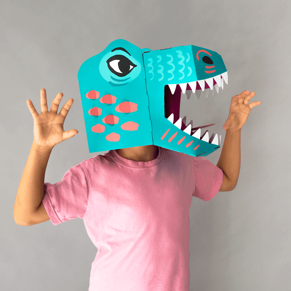 OMY Dino 3D mask worn by child; teal dinosaur head with open jaws for imaginative play.