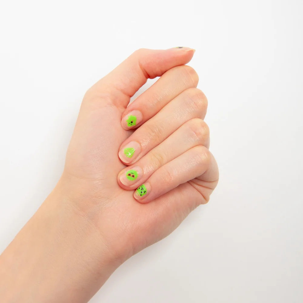 OMY Glow party nail stickers on a hand, bright lime nails with tiny cute faces in action.