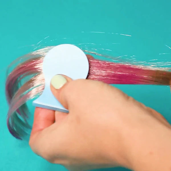 OMY Hair Chalk applied to pink-highlighted hair with a blue circular applicator on teal background.