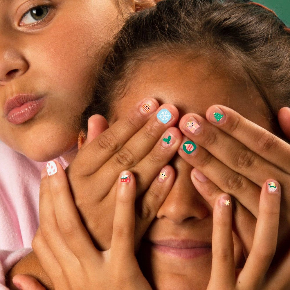 OMY Ho Ho Ho Holiday nail stickers on colorful nails as kids cover their faces playfully.