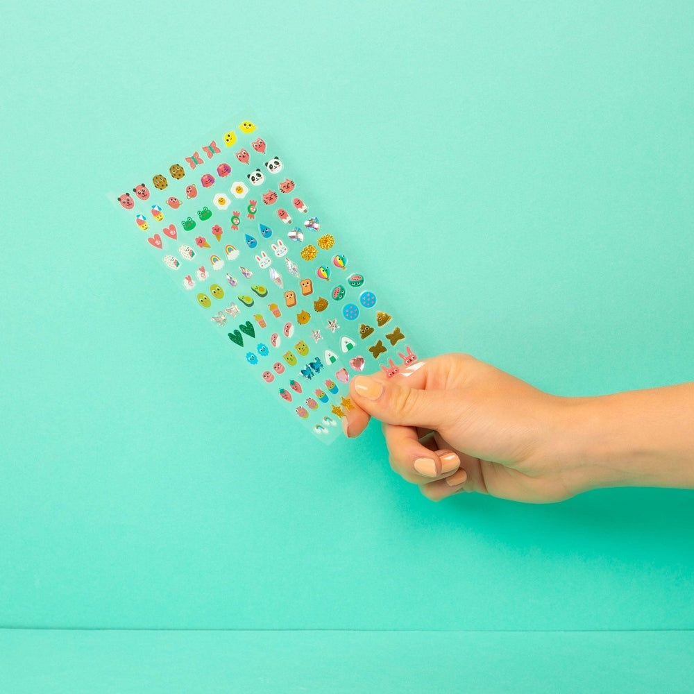 OMY Kids Sticker Earrings - Kawaii: hand holds a sheet of colorful emoji stickers for earrings.