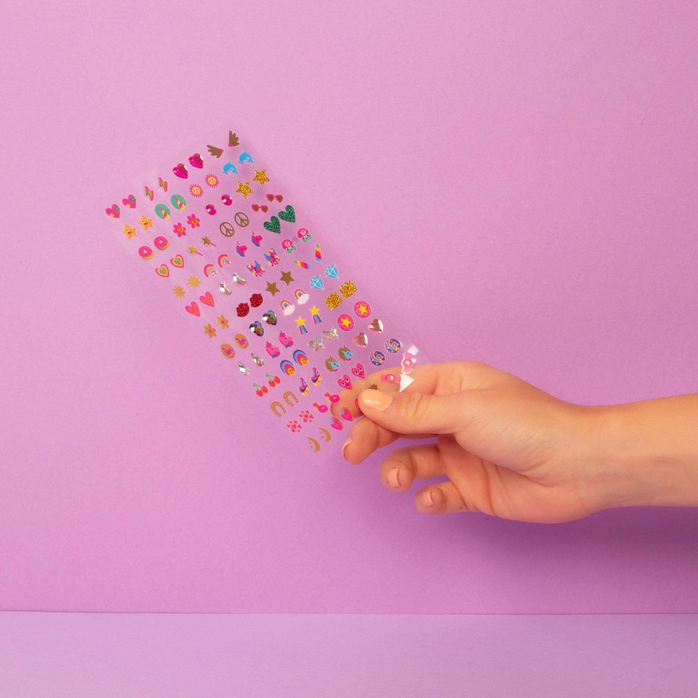 OMY Kids sticker earrings Unicorn sheet held in a hand against pink background, colorful peelable shapes