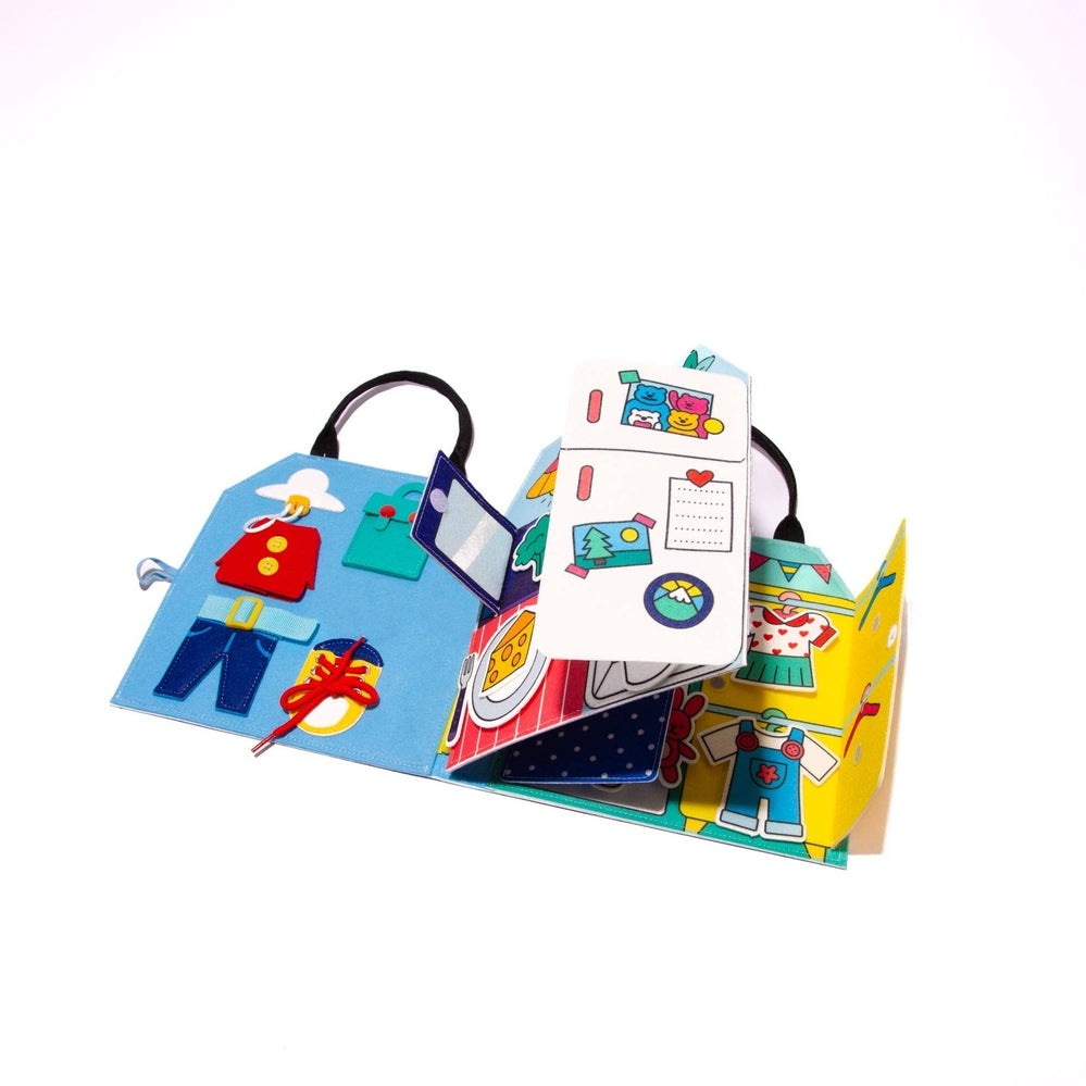 OMY Montessori Play Kit, a colorful fold-out activity book with clothing pieces and picture cards for imaginative sorting.