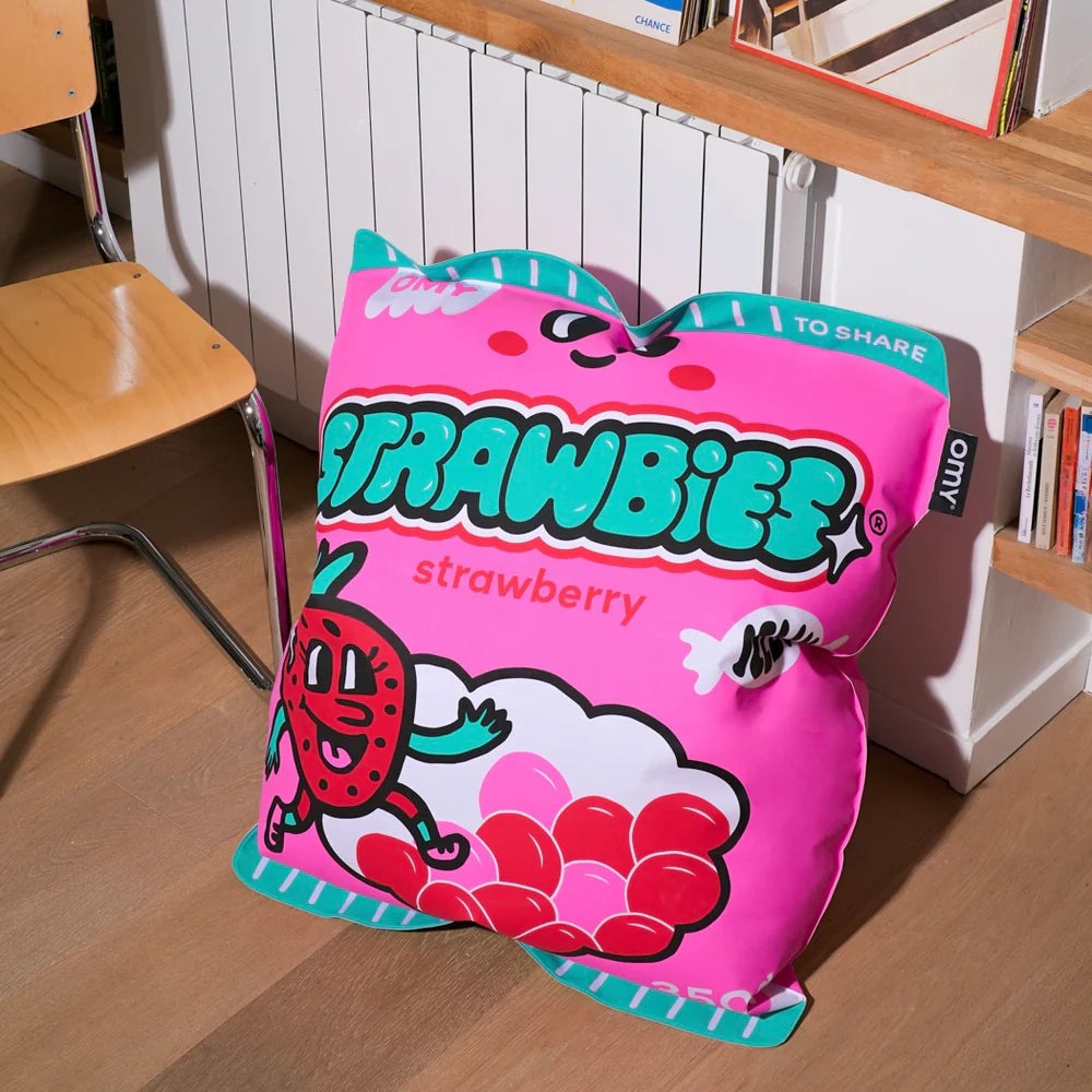 OMY Strawbies Giant Inflatable Pillow in pink with teal trim, resting on the floor as a playful decorative cushion.