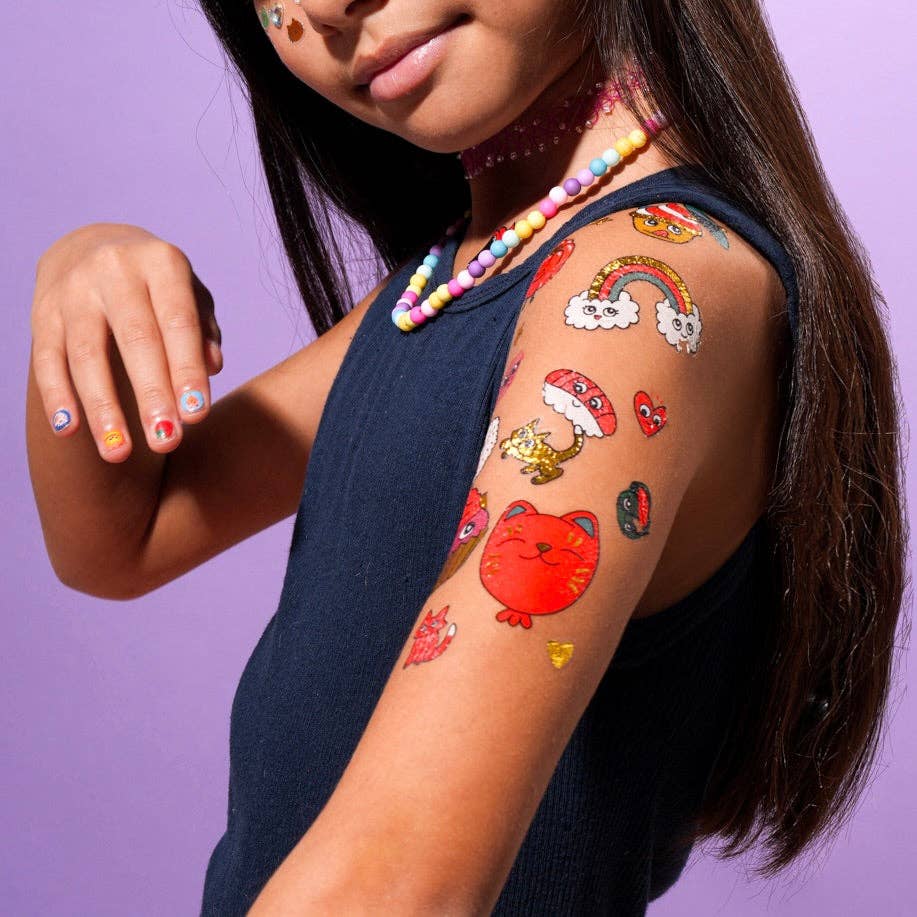 OMY Tattoos Kawaii temporary tattoos on a girl's arm, featuring colorful cute stickers and a rainbow design.
