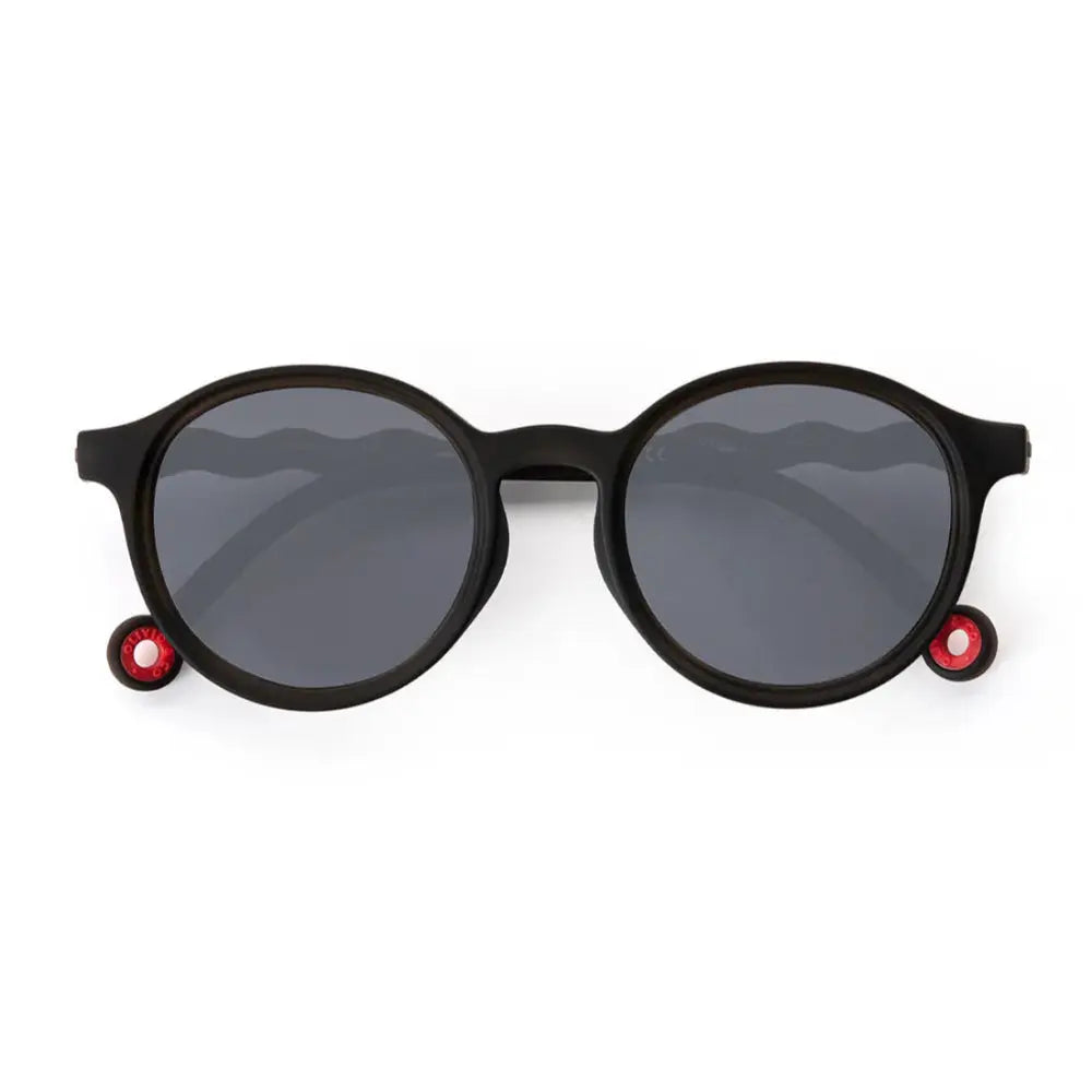 Olivio & Co Oval Sunglasses Kids/Junior Classic Olivio Squid Black, black frame with dark gray lenses and red temple accents.