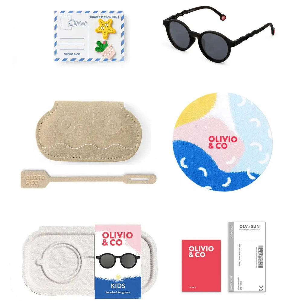 Olivio & Co Oval Sunglasses Kids/Junior Classic in black, shown with soft beige case and colorful accessories.