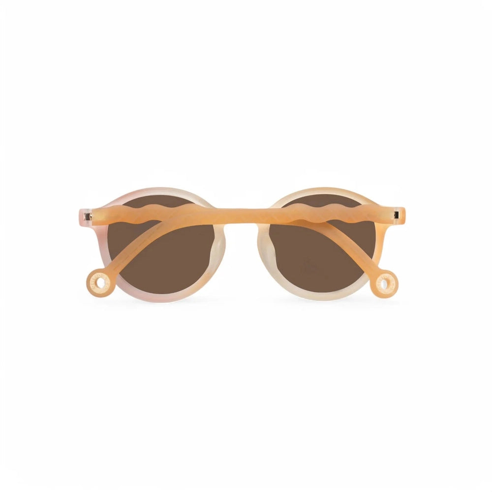 Olivio & Co kids oval sunglasses with peach translucent frames and brown lenses, wavy arms
