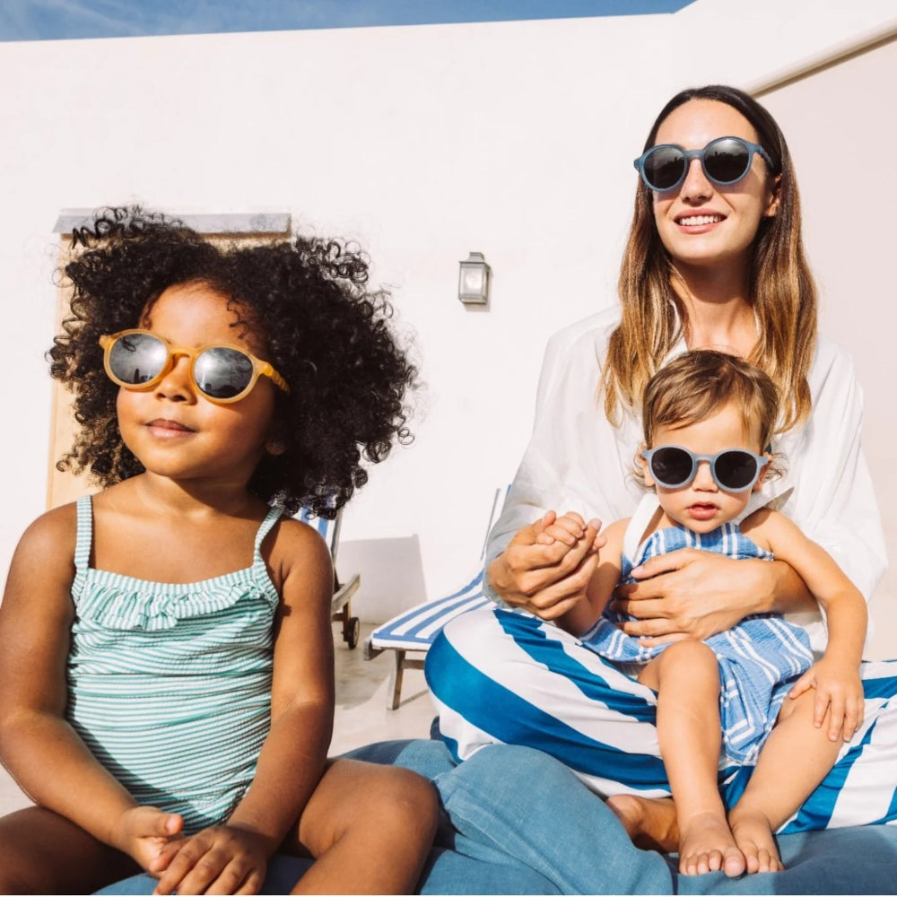 Olivio & Co oval kids sunglasses in seaside stripes yellow; family outdoors wearing them