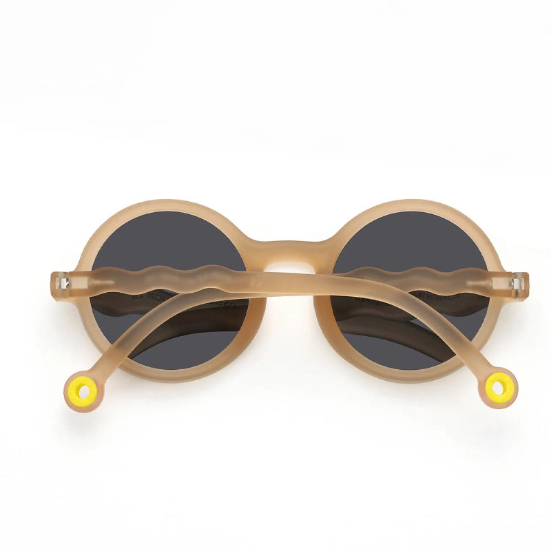 Olivio & Co Round Sunglasses Kids Sand Beige with dark lenses, shown with wavy beige temples secured across.